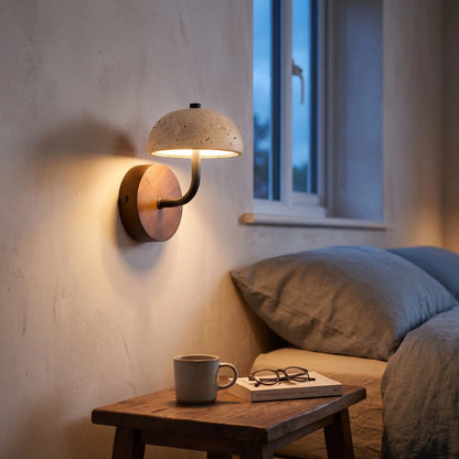 Travertine stone dome wall light on a wooden backplate above a bedside table
