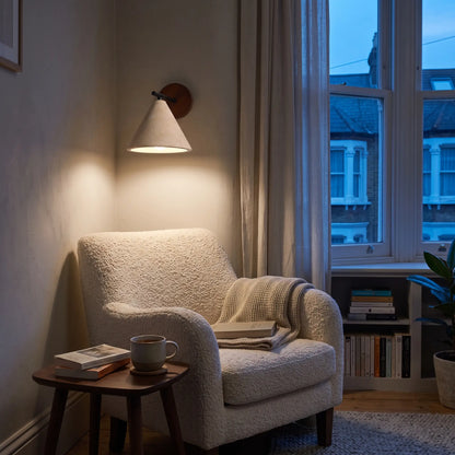 Travertine cone wall lamp above an armchair in a reading nook