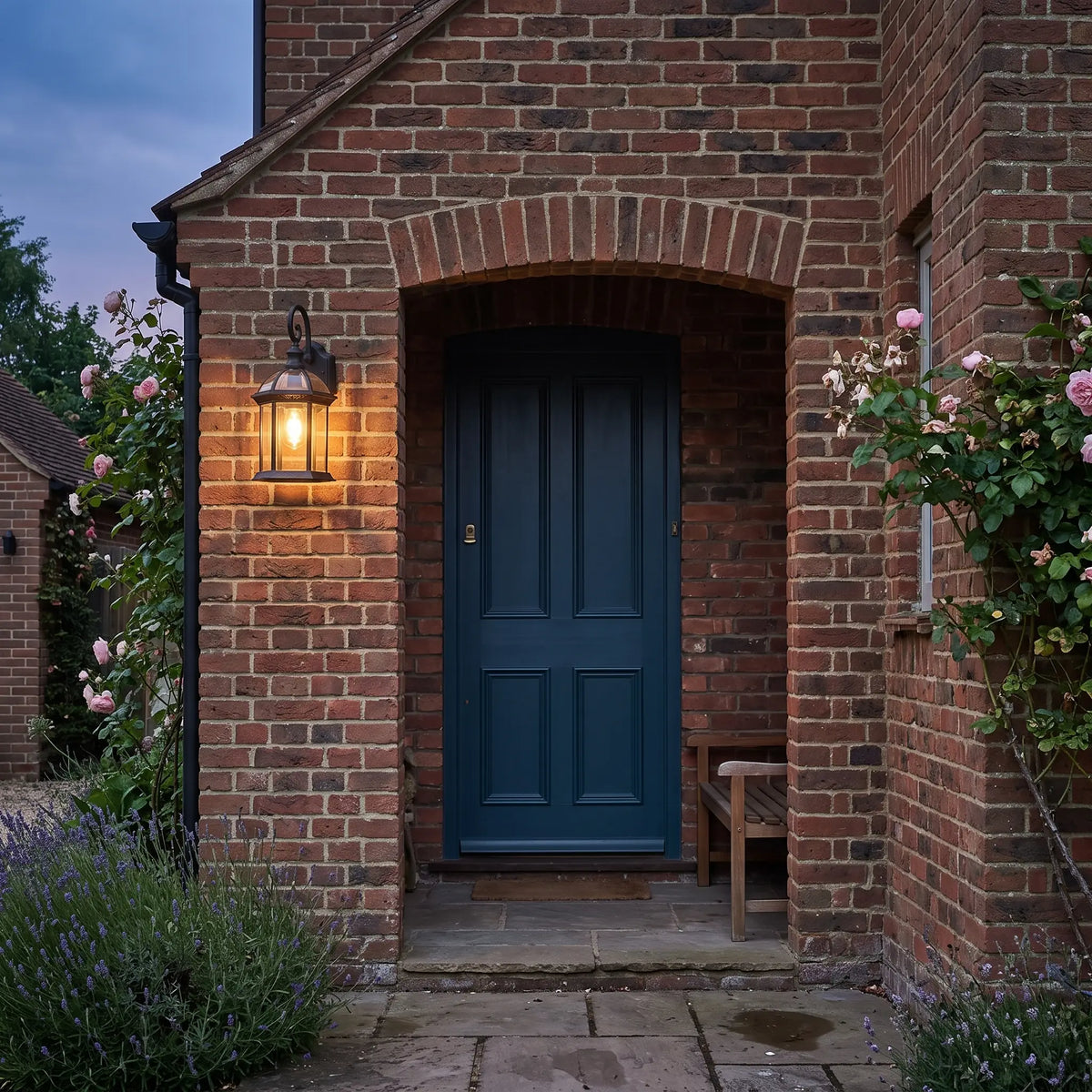 Black hexagonal outdoor wall lantern beside a front door at dusk
