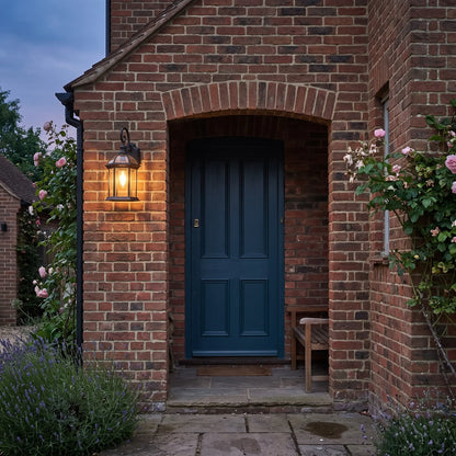 Black hexagonal outdoor wall lantern beside a front door at dusk