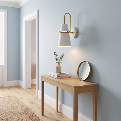 White Nordic cone wall light with brass ring above a hallway console