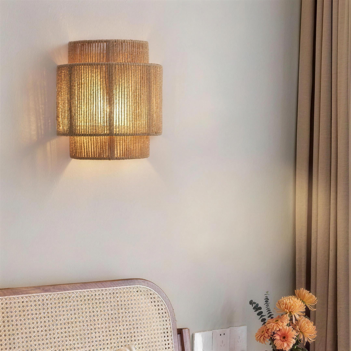 Tiered rope wall light glowing above a bed