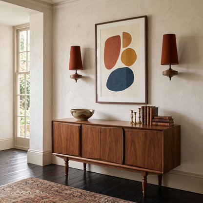 Pair of rust red fabric wall lights either side of a print above a sideboard