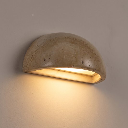 Close-up of half moon travertine wall light shining light downwards