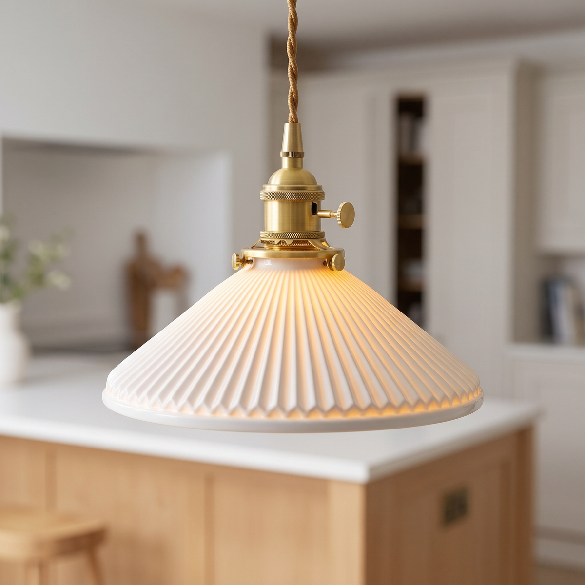 Japanese pleated white ceramic pendant light with brass top, close-up in a kitchen
