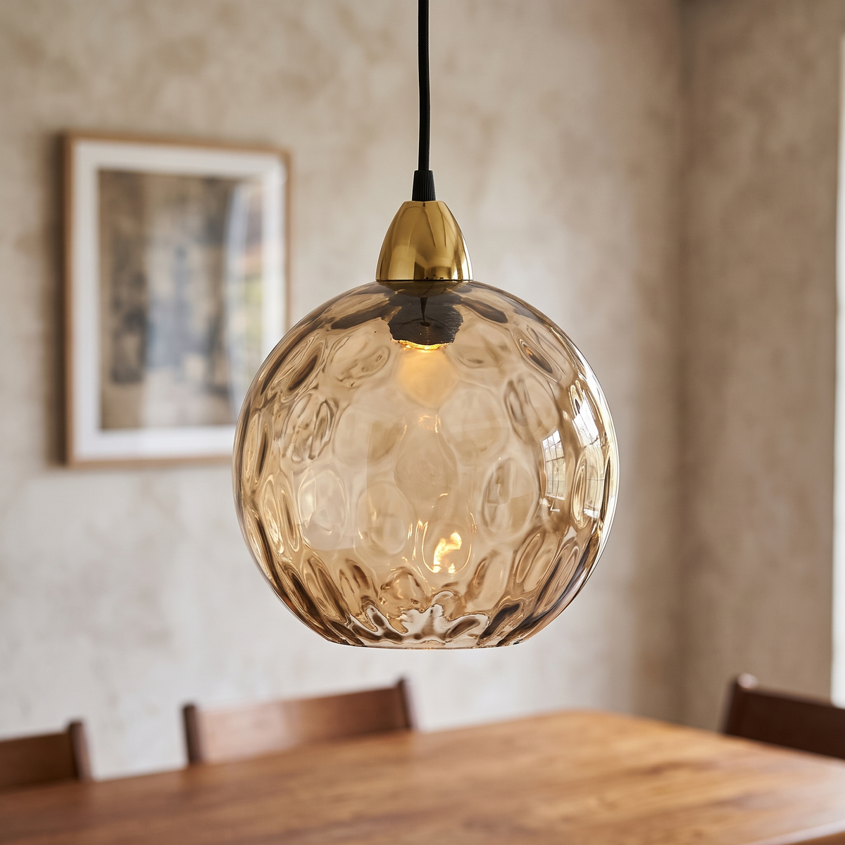 Amber rippled glass globe pendant light, close-up in a dining room