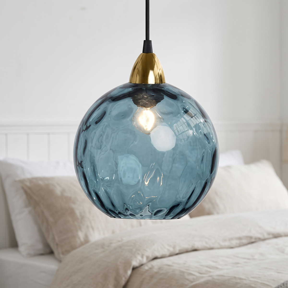 Dark blue rippled glass globe pendant light, close-up in a bedroom