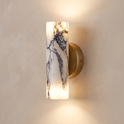 Natural marble up and down cylinder wall light with brass back plate, close-up