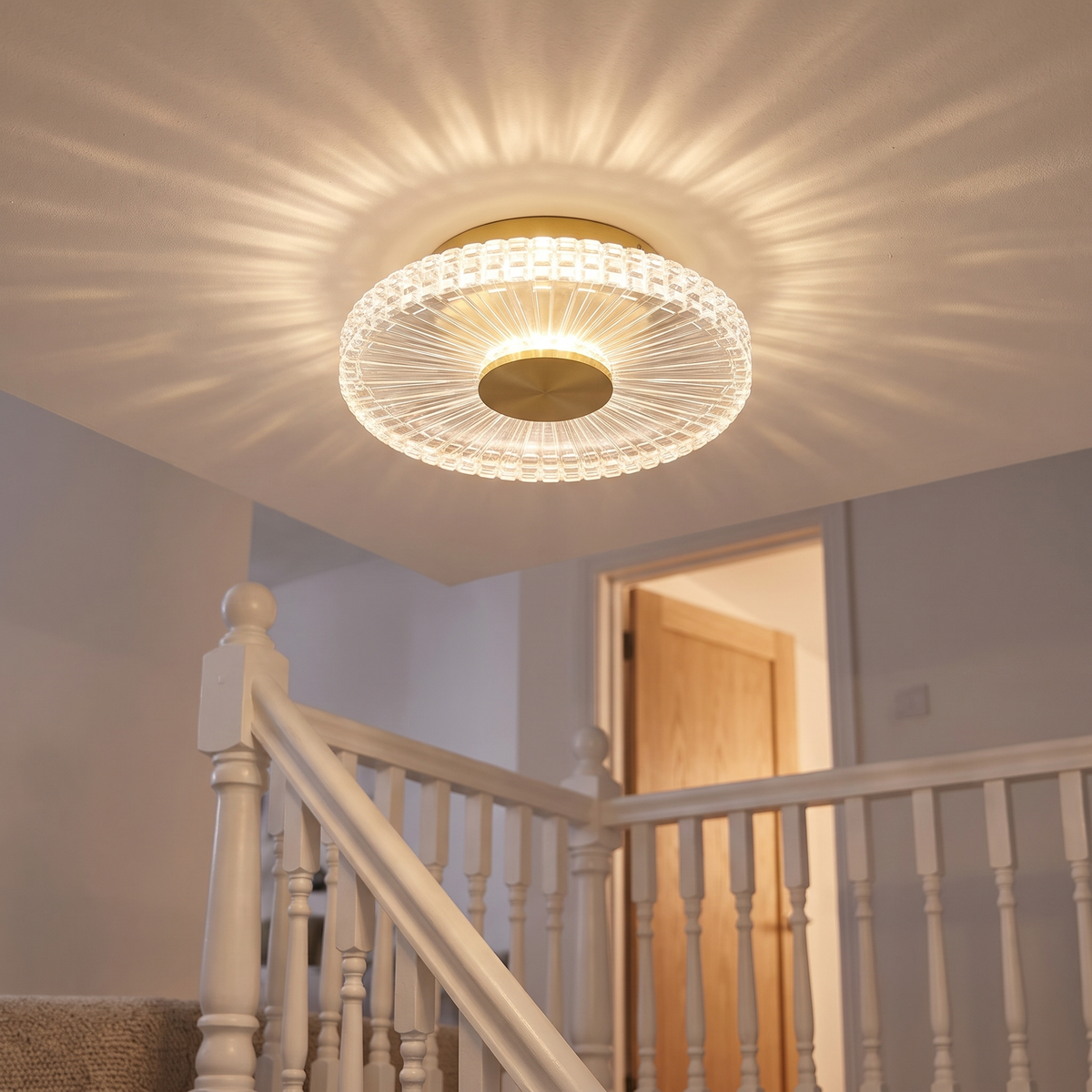 Small gold crystal-effect flush ceiling light lit on an upstairs landing ceiling