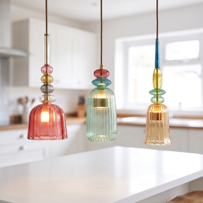 Red, green and amber coloured glass mini pendant lights in a row over a kitchen island