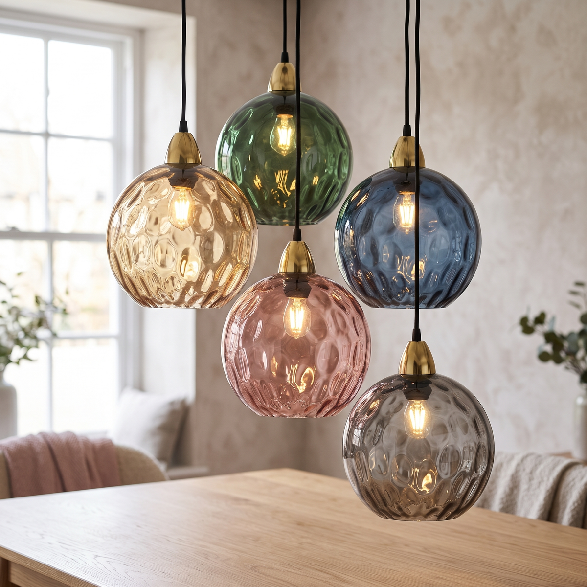 Cluster of five rippled glass globe pendant lights in amber, green, blue, rose and smoke over a dining table