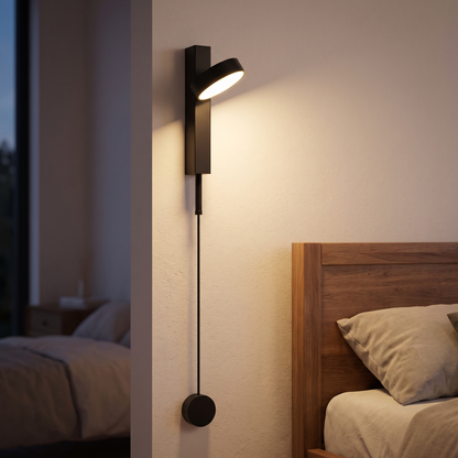 Black rotating-head rod LED wall reading light mounted beside a bed