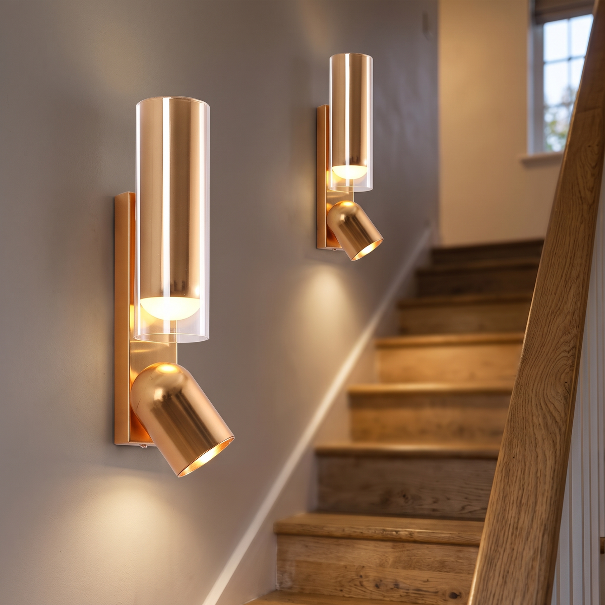 Two brass up and down spotlight wall lights along a staircase wall