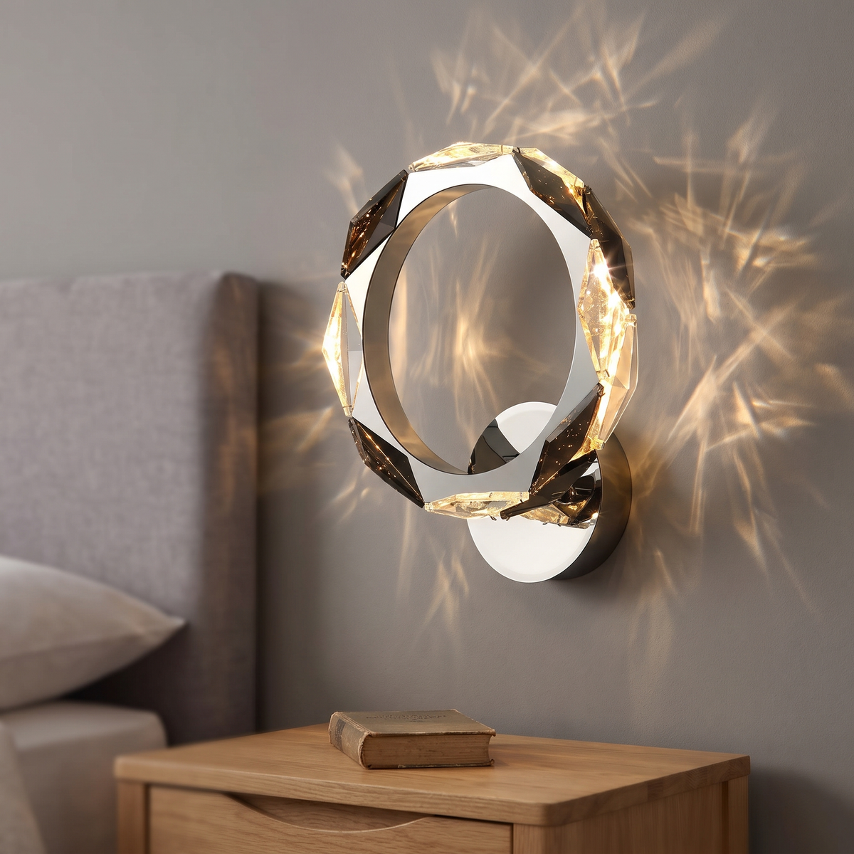 Chrome crystal ring LED wall light, 29cm, lit on a bedroom wall beside the bed