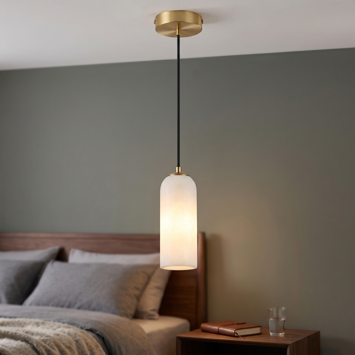 Natural marble capsule mini pendant light with gold ceiling canopy, hung beside a bed
