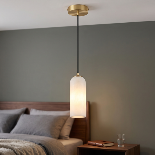 Natural marble capsule mini pendant light with gold ceiling canopy, hung beside a bed