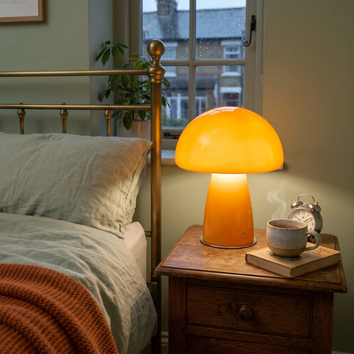 Orange glass mushroom table lamp on a bedside table