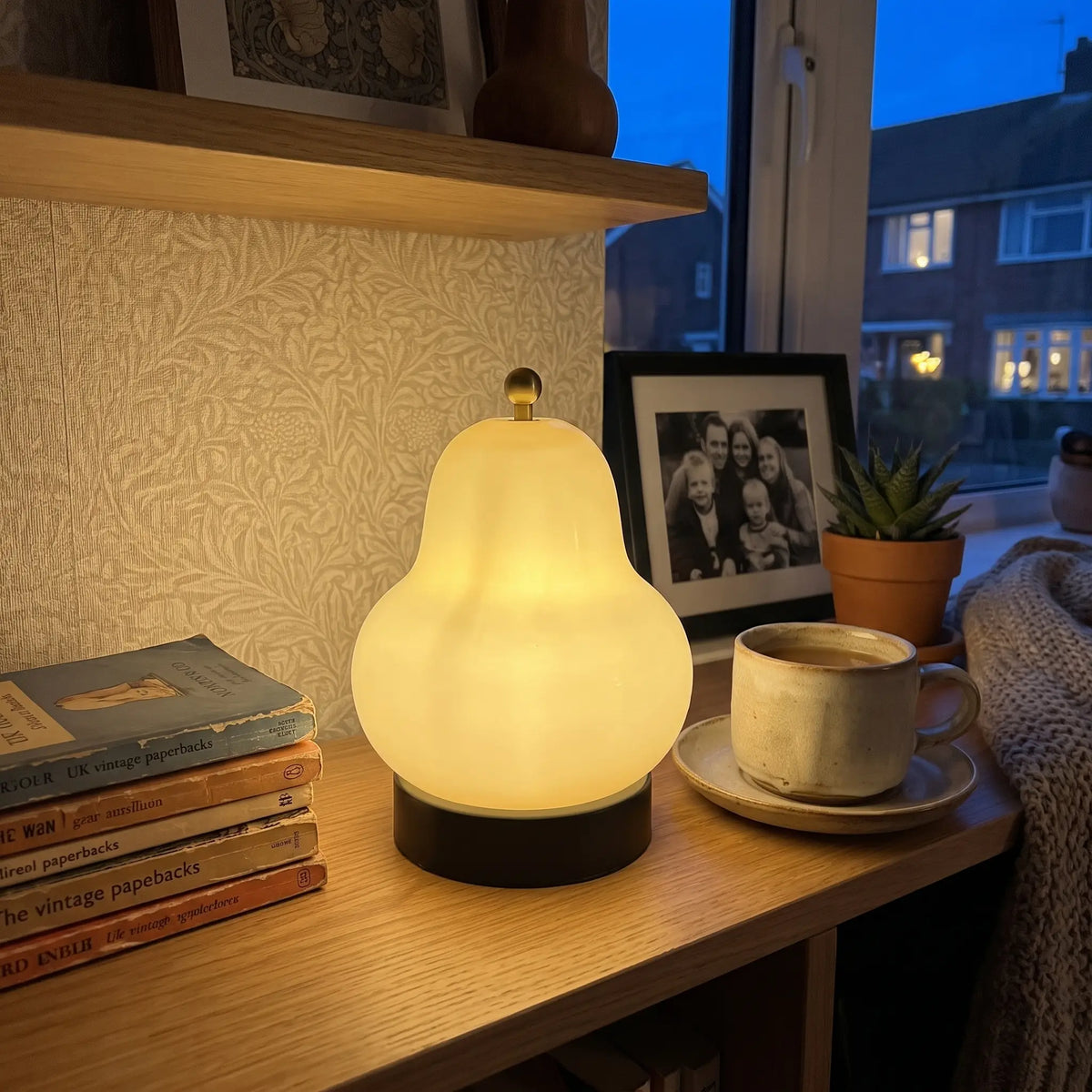 Cream pear-shaped glass table lamp on a shelf