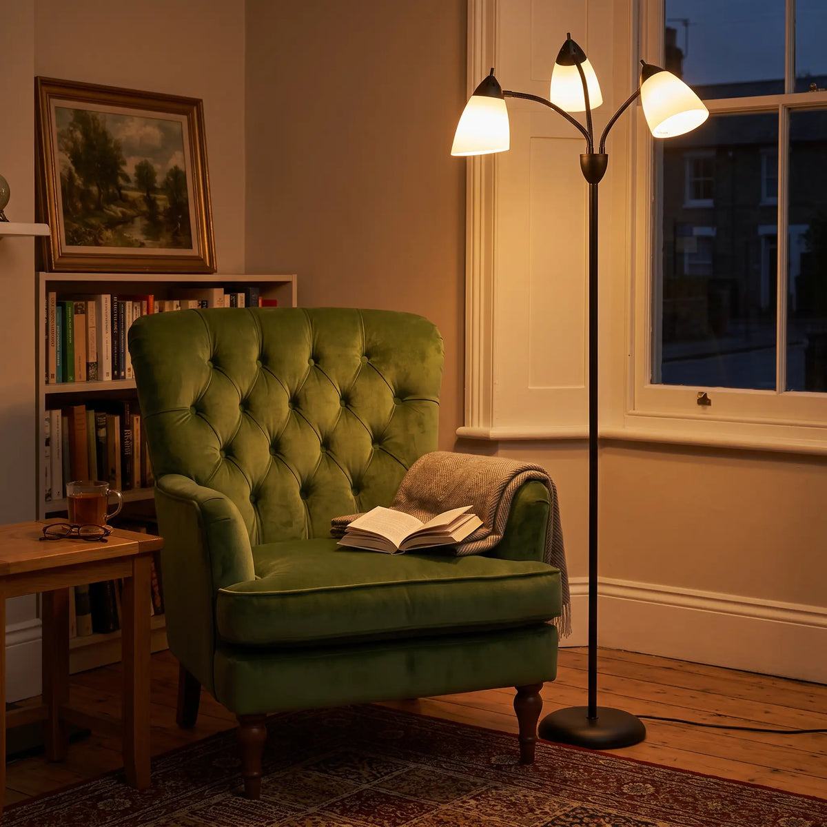 Black 3-light arc floor lamp beside a green armchair
