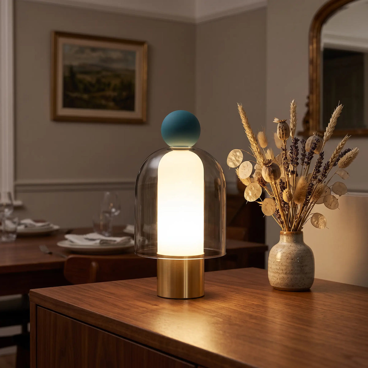 Smoky grey glass cordless lamp with blue top on a sideboard