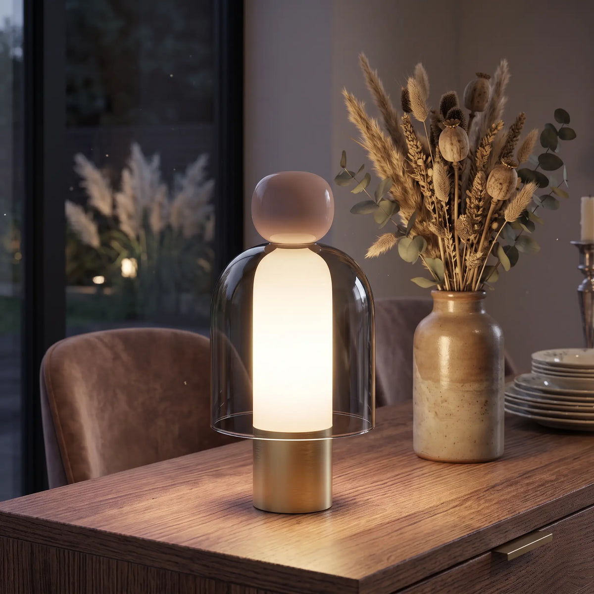 Smoky grey glass cordless lamp with pink top on a sideboard
