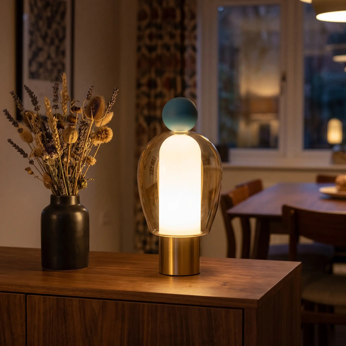 Cognac glass cordless lamp with blue top on a sideboard