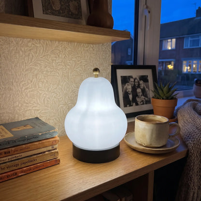 Milky white pear glass table lamp with black base on a shelf