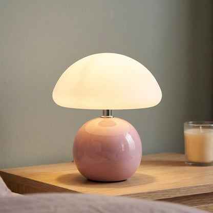Pink ceramic mushroom table lamp on a nightstand