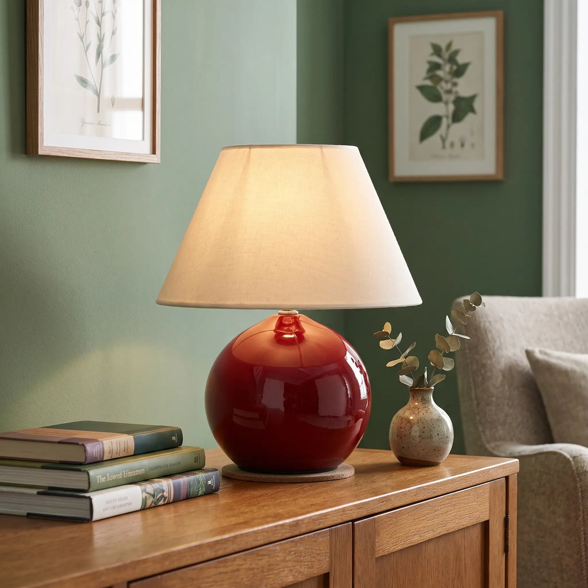 Red ceramic ball table lamp on a living room sideboard