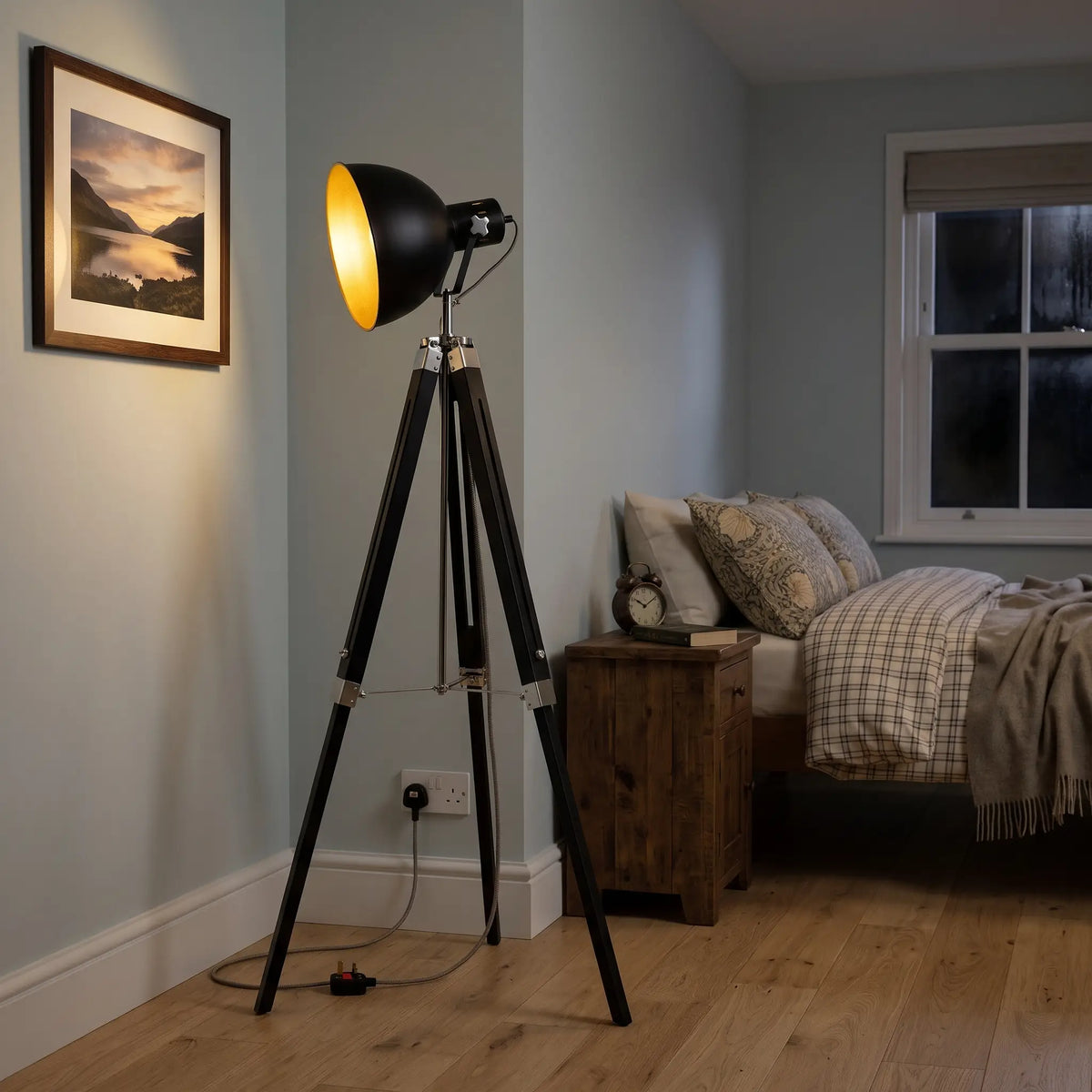 Retro tripod spotlight floor lamp in a bedroom corner