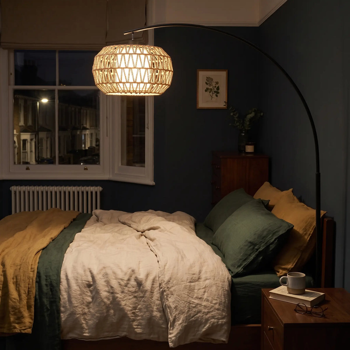 Boho arc floor lamp over a bed at night