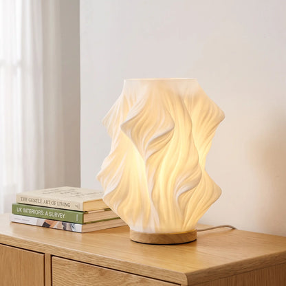 Drape sculpted table lamp with wooden base on an oak sideboard