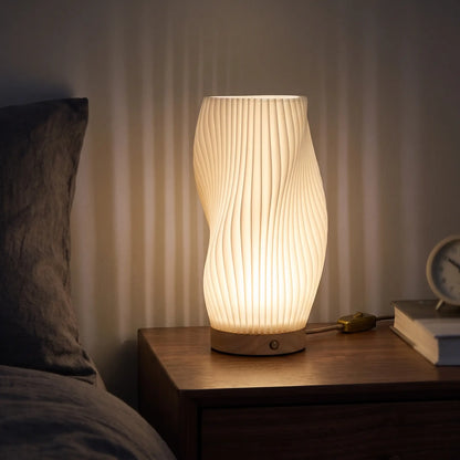 Twist ribbed table lamp lit at night on a bedside table