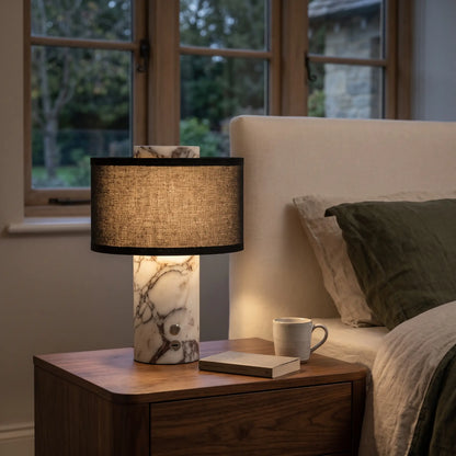 Cordless grey marble table lamp with black shade on a bedside table