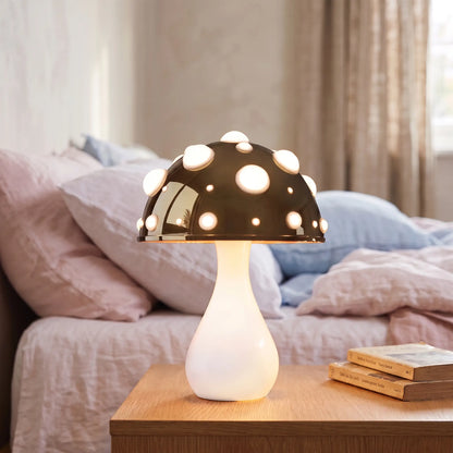 Dark gold toadstool mushroom lamp with white stem on a bedside table