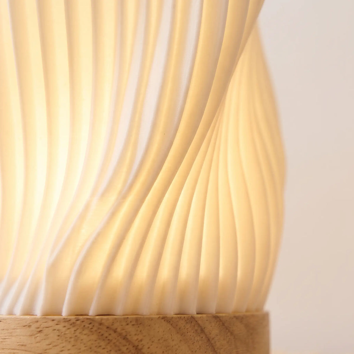 Close-up of the glowing ribbed shade and wooden base