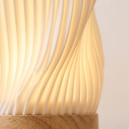 Close-up of the glowing ribbed shade and wooden base