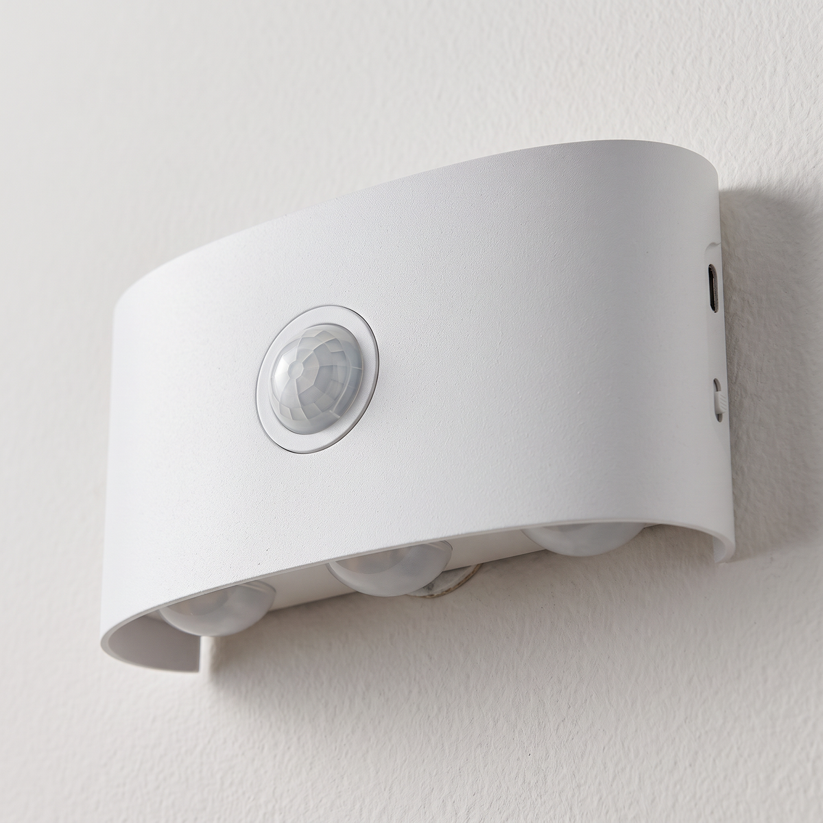 Close-up of the curved white motion sensor wall light