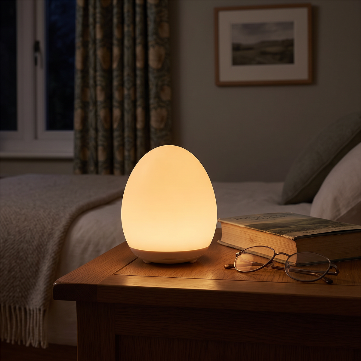 Egg night light glowing amber on a bedside table