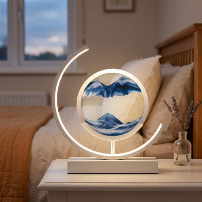 Rechargeable sand art lamp with blue moving sand on a bedside table