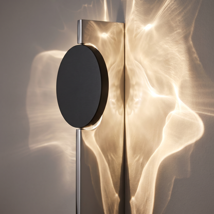 Close-up of the polished steel sheet and black disc of the ripple wall light